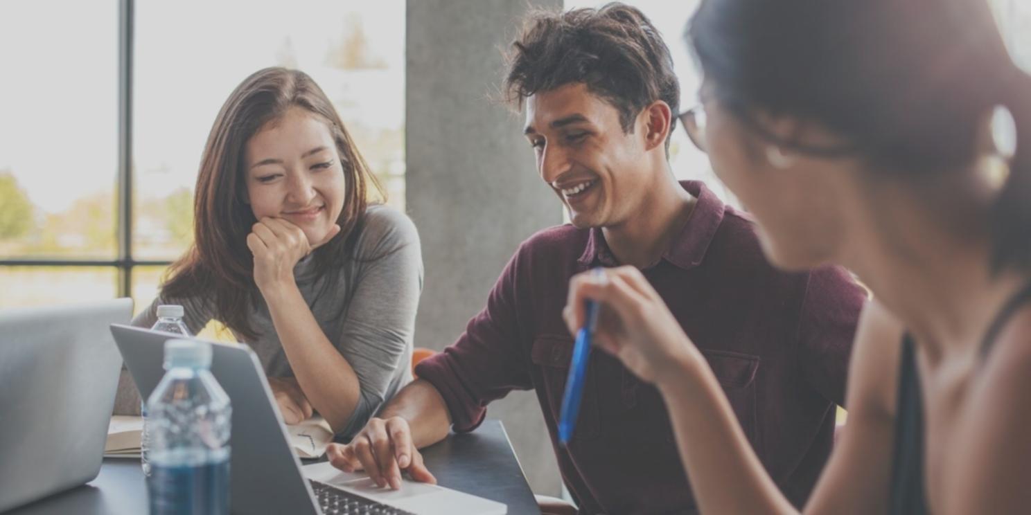 Estudiante preparando su espacio de estudio con ordenador y materiales organizados